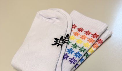 weiße Socken mit Edelweiß Logo in Regenbogenfarben